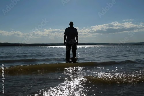 Cooling feet in the waves. Facing west away from the camera, he's chilling his feet on a hot day. Just off the shore of Glendo Reservoir. Long pants worn because of having ugly legs. photo