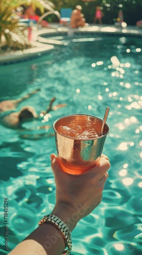 Person Holding Drink in Front of Swimming Pool at Summer Party