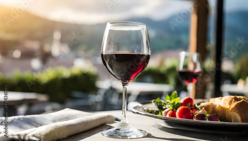 Glass of red wine dining at restaurant terrace blurred background