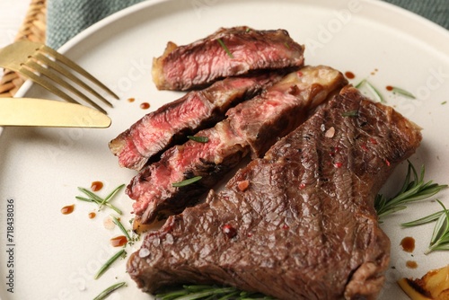 Delicious grilled beef steak and rosemary on plate, closeup