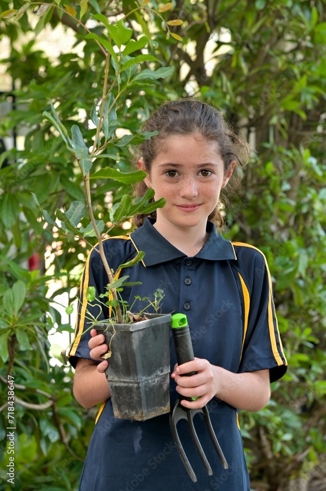 Jewish girl planting a new tree in the garden on Tu Bishvat Jewish