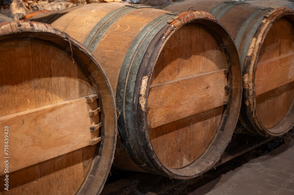 Wine cellar with wooden barrels in old wine domain on Sauternes vineyards in Barsac village affected by Botrytis cinerea noble rot, making of sweet dessert Sauternes wines in Bordeaux, France Wine cellar with wooden barrels in old wine domain on Sauternes vineyards in Barsac village affected by Botrytis cinerea noble rot, making of sweet dessert Sauternes wines in Bordeaux, France
