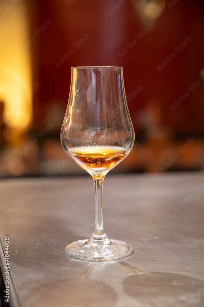 Obraz premium Tasting of cognac spirit aged in old French oak barrels in cellar in distillery in Cognac white wine region, Charente, Segonzac, Grand Champagne, France