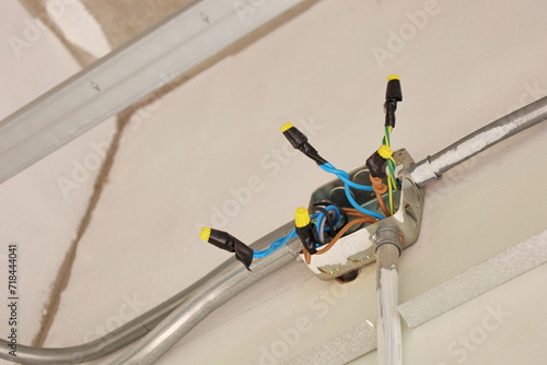Wire Nut connects electrical wires in a junction box. Using plastic insulation clamps, wire nuts to connect twisted wires in a distribution box on a concrete wall. Selective focus. photo
