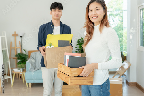 Moving house, relocation. Couple help set and move furniture for new apartment, inside the room was a cardboard box contain personal belongings. move in the new apartment or condominium