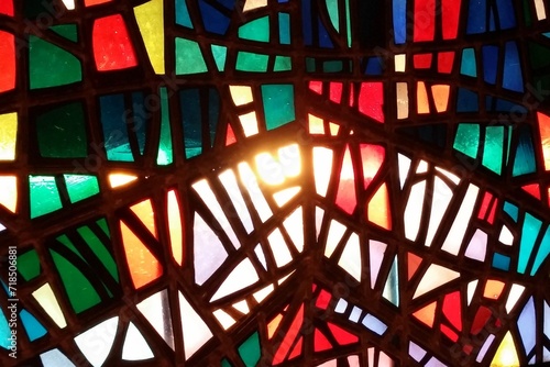 Closeup detail of a stained glass window with sun shining through