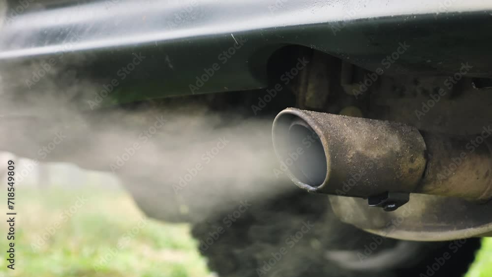 Smoke coming out of the exhaust pipe of a stationary car. Large jets of exhaust gases from exhaust pipe, concept of air pollution. Slow motion. Close-up Smoke coming out of the exhaust pipe of a stationary car. Large jets of exhaust gases from exhaust pipe, concept of air pollution. Slow motion. Close-up