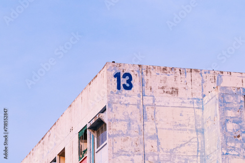 Outside atmosphere of old apartment thirteenth building sky cloudy sunlight and shadows atmosphere bright Thailand. There many people live slums, mostly foreign countries. 13 (bad luck number). photo