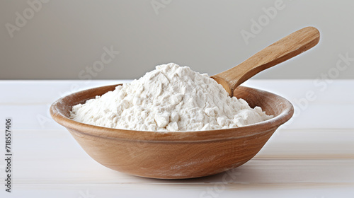 A heap of flour in a bowl on a table.