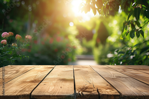 A wooden table with no objects on it and a blurred outdoor garden background. The wooden table provides space for text and can be used for marketing promotions