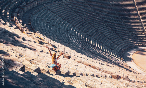 Female tourist enjoying the ancient theatre of Epidaurus, Peloponnese in Greece