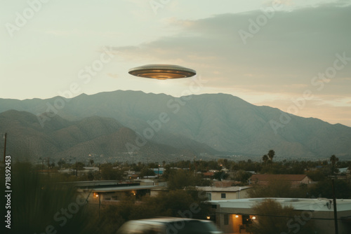 An unidentified flying object hovers over a mountainous desert landscape at dusk, sparking theories of extraterrestrial visitation and mystery.