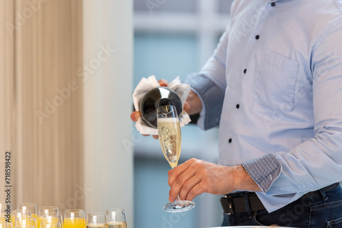 closeup of masculine hands pouring champagne into a glass