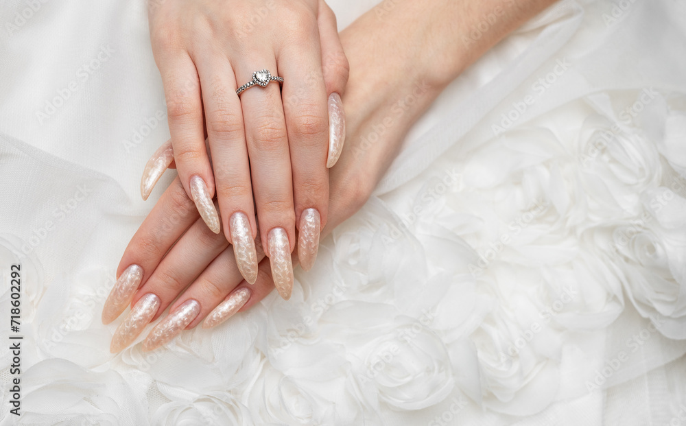 Hand of a young woman with white pearl  manicure