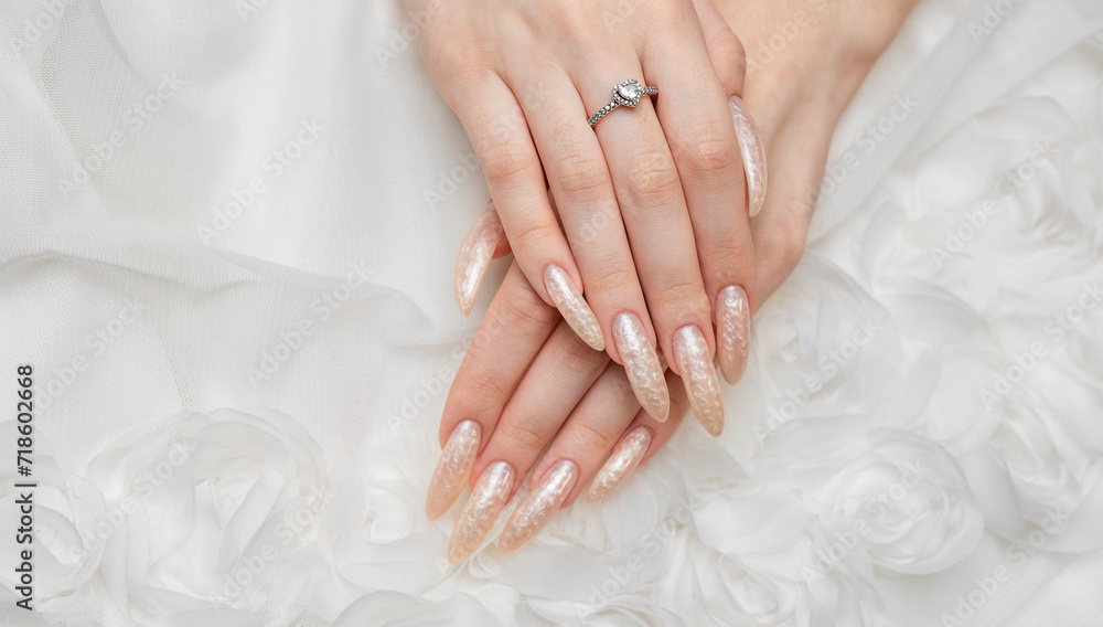 Hand of a young woman with white pearl manicure Hand of a young woman with white pearl manicure