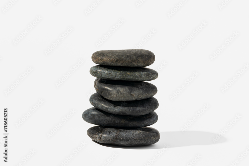 Stacked black spa pebbles on white background Stacked black spa pebbles on white background