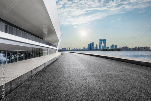 Empty asphalt road and city skyline background