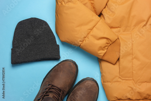 Set of men's winter clothes on blue background. Top view