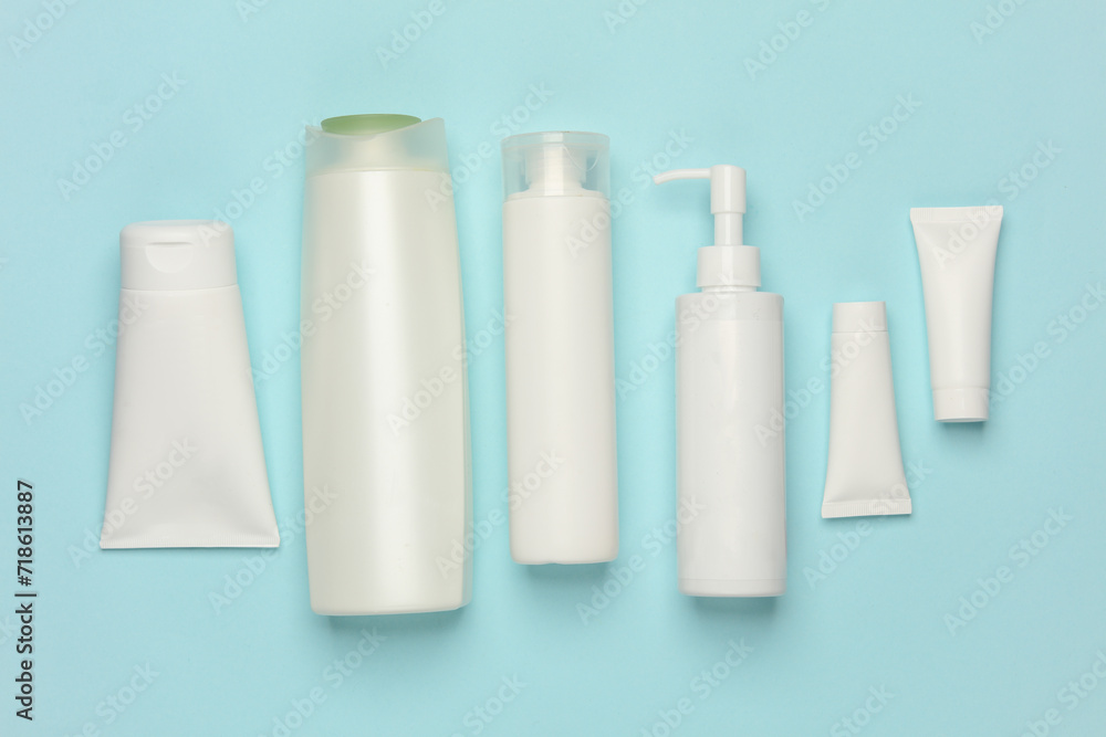 Tubes, bottles and jars of cosmetics on a blue background