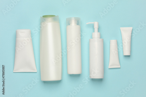 Tubes, bottles and jars of cosmetics on a blue background
