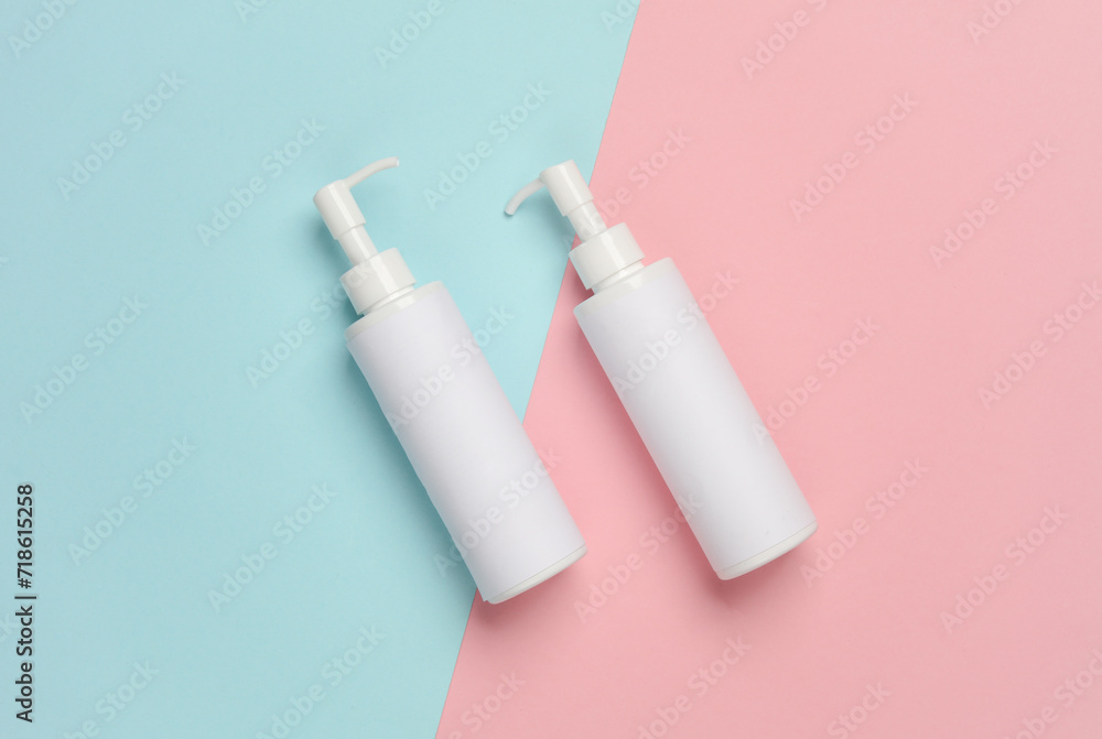Bottles of cream with dispenser on a blue-pink background Bottles of cream with dispenser on a blue-pink background