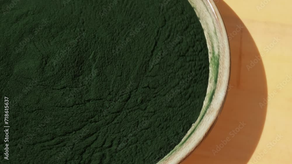 Rotating Organic bluegreen algae spirulina powder food in plate