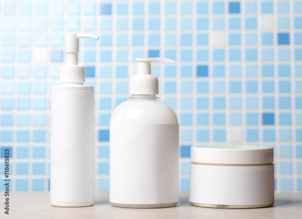 Bottles of cosmetics in bathroom on tile background Bottles of cosmetics in bathroom on tile background