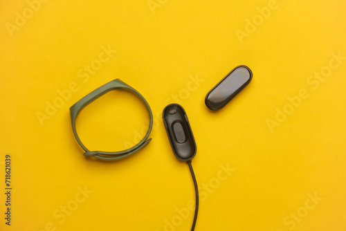 Smart bracelet with charger on yellow background