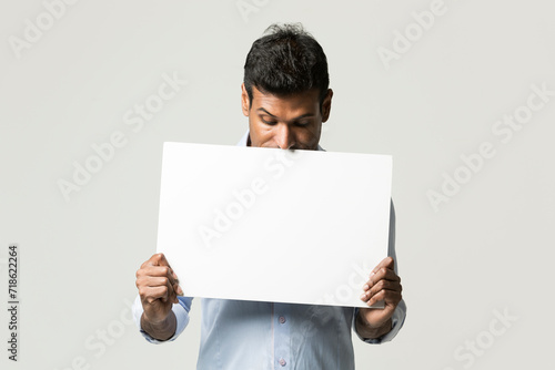 Indian man holding up a banner.