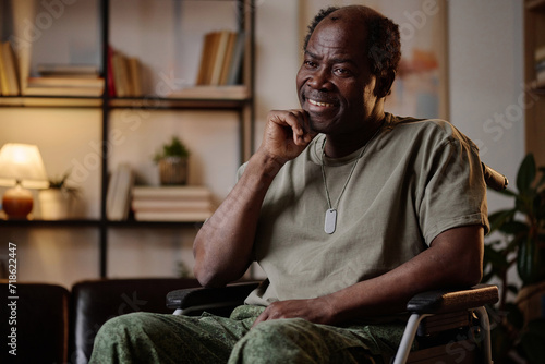 Cheerful senior african american war veteran in military uniform sitting in wheelchair photo