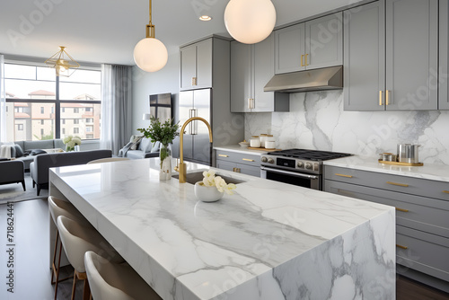 A stylish kitchen in Chicago with gold hardware, stainless steel appliances, and white marbled granite counters. photo