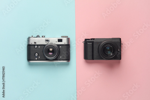 Modern digital and film cameras on a blue pink background