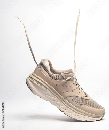 Sport sneaker with flying laces on a white background