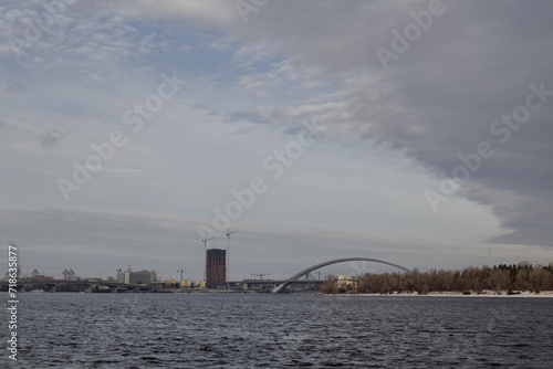 Kyiv, Ukraine - January 19, 2024: it's cold outside, minus temperature, gray sky. the Dnipro River froze over. From a height you can see the beautiful architecture near the embankment and on Podil