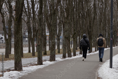 Kyiv, Ukraine - January 20, 2024:cozy sleeping district of Borshchagivka. people are walking in the park on a day off.There are many different trees in Yunist Park. is located near residential buildin