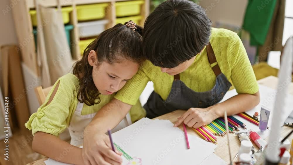 Artist teacher and student drawing on canvas together in art studio lesson, concentrating and learning creatively indoors Artist teacher and student drawing on canvas together in art studio lesson, concentrating and learning creatively indoors