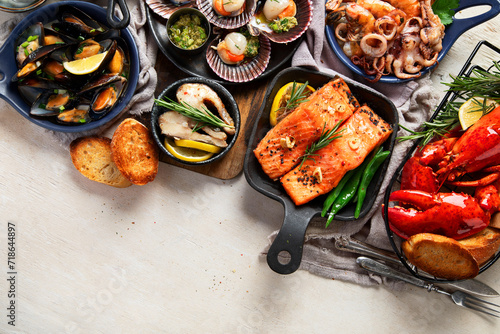 Set of Seafood dishes on light wooden background.