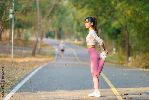 Young female runner stretching arms before running in the morning. Women stretch to warm up before running or working out. Fitness and healthy lifestyle concept. 