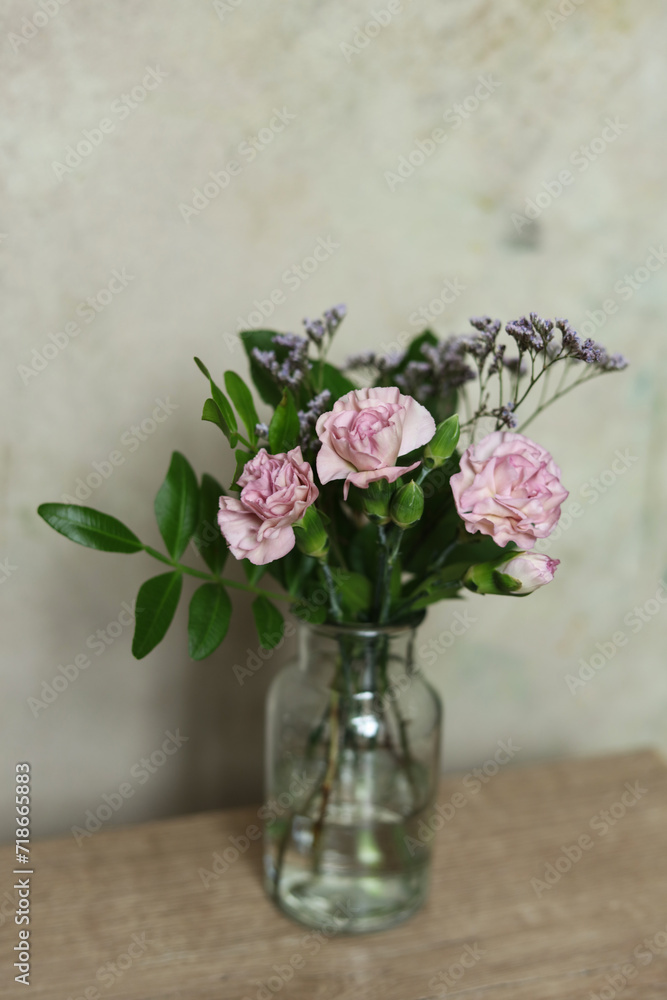 Bouquet of pink carnation flowers in a glass vase on the table Bouquet of pink carnation flowers in a glass vase on the table