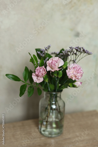 Bouquet of pink carnation flowers in a glass vase on the table