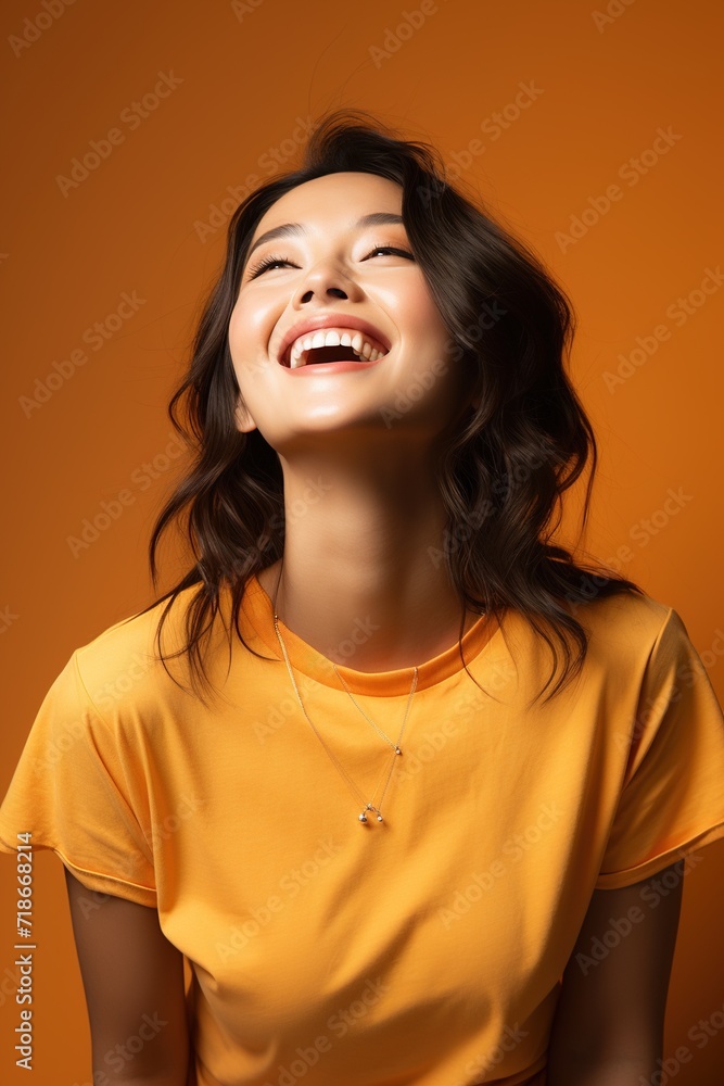 Portrait of a young Asian woman laughing with her head back Portrait of a young Asian woman laughing with her head back