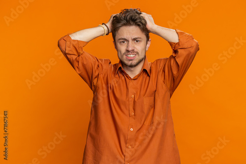 Fotografie Sad young Caucasian man feeling hopelessness loneliness, nervous breakdown, loses becoming surprised by lottery results, bad fortune, loss unlucky news