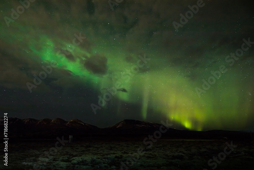 Northern Lights forming in a slightly cloudy sky, Iceland