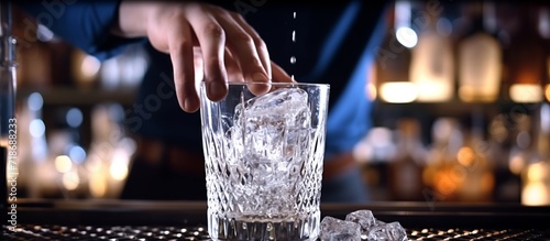 pouring beer in a glass with ice cubes, bartende.