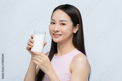 Portrait young asian woman drinking milk from the glass isolated over white background