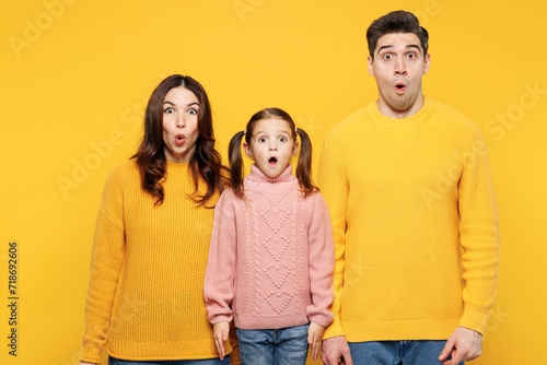 Young sad surprised astonished startled scared shocked parent mom dad with child kid girl 7-8 years old wear pink knitted sweater casual clothes isolated on plain yellow background Family day concept photo
