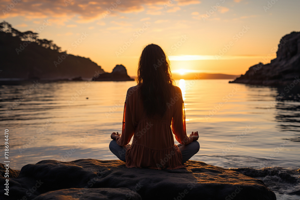 A girl meditates in a pose on the shore of the sea, lake in the rays of the sunset. Generated by artificial intelligence