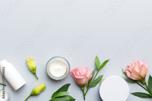 Composition with cosmetic products and beautiful roses on color background. Copy space  flat lay