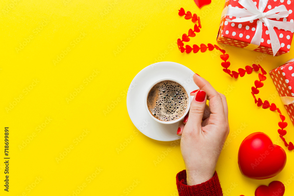 Flat lay of heart shaped cup of black coffee in the hands of women on colored background with copy space top view. Valentine day and holiday concept Flat lay of heart shaped cup of black coffee in the hands of women on colored background with copy space top view. Valentine day and holiday concept