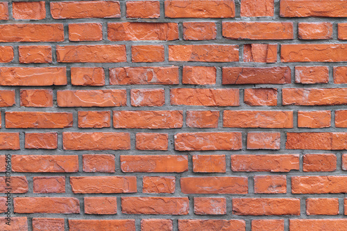 Decayed, orange brick wall with damaged bricks